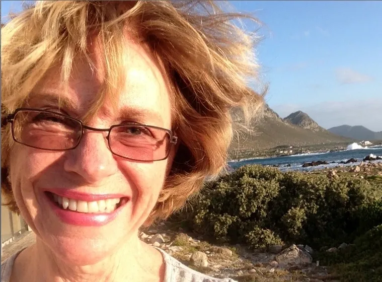 A woman with glasses smiling for the camera.