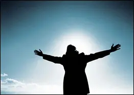 A person with arms outstretched in front of the sun.